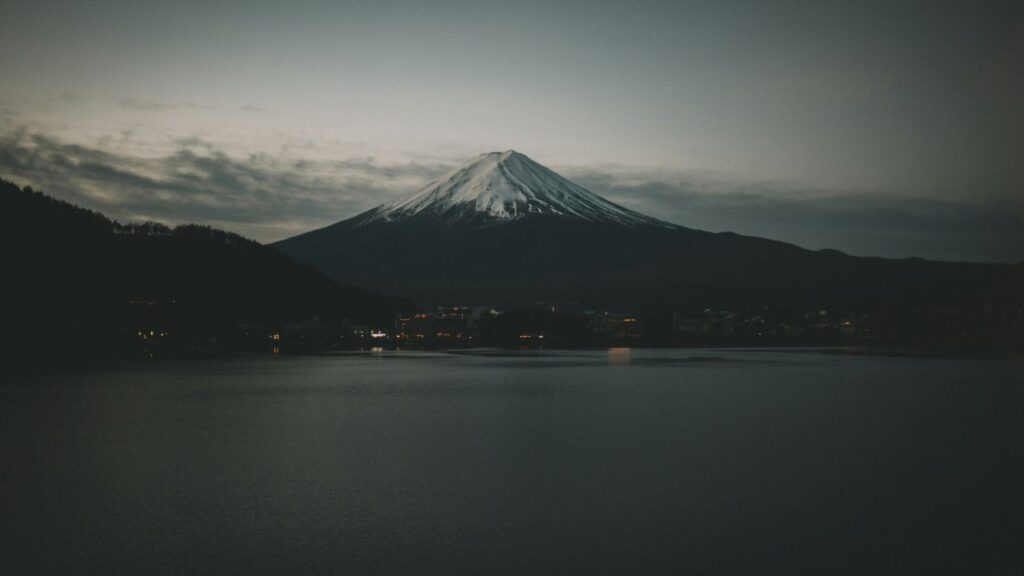 Minimalist photograph of Mount Yōtei at dusk emphasizing misty peaks